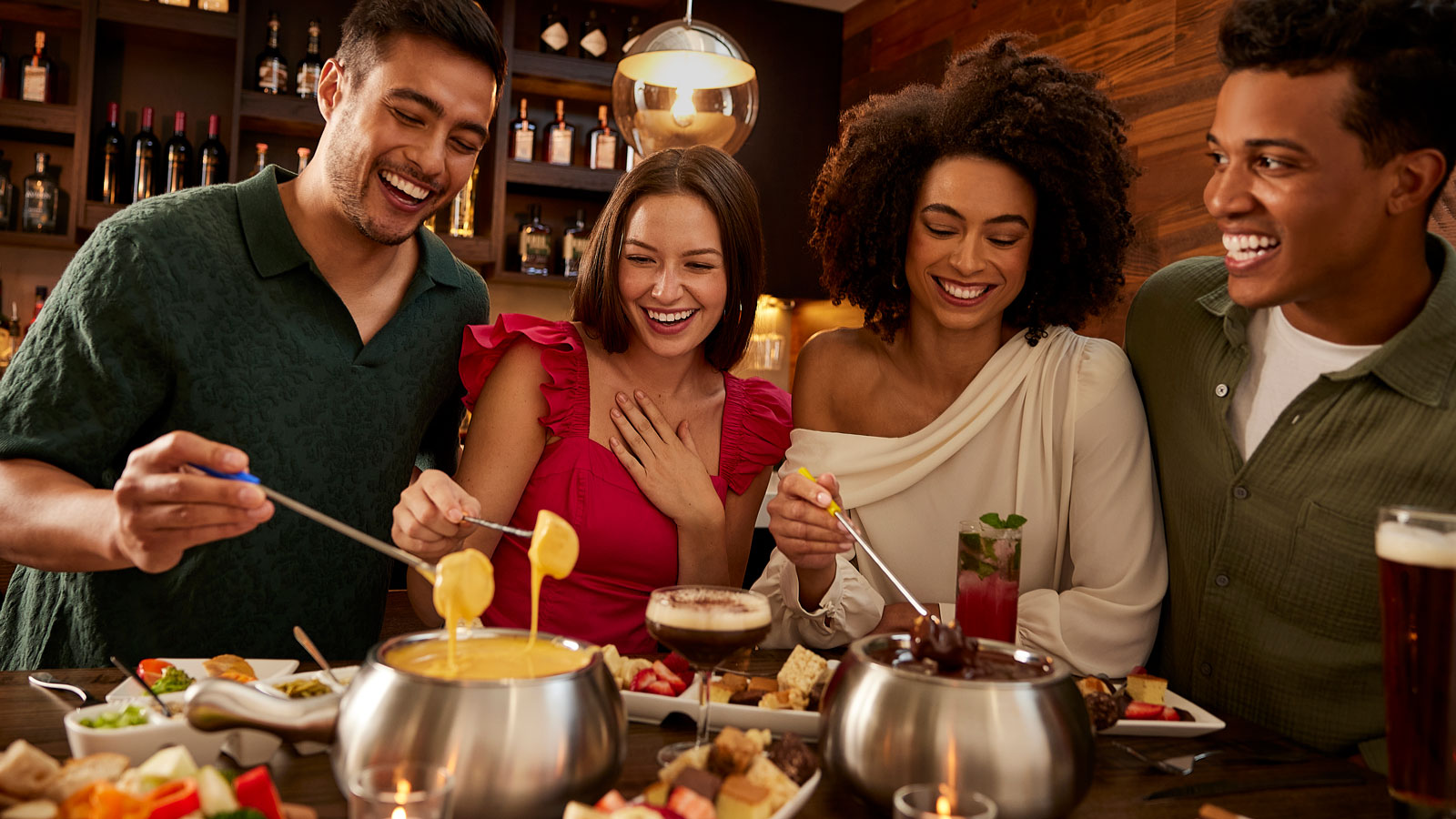 a group of people smiling at a table with fondue