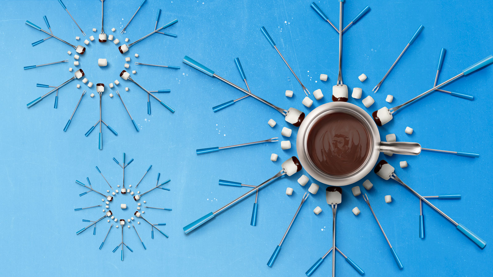 fondue pot and forks arranged to look like snowflakes